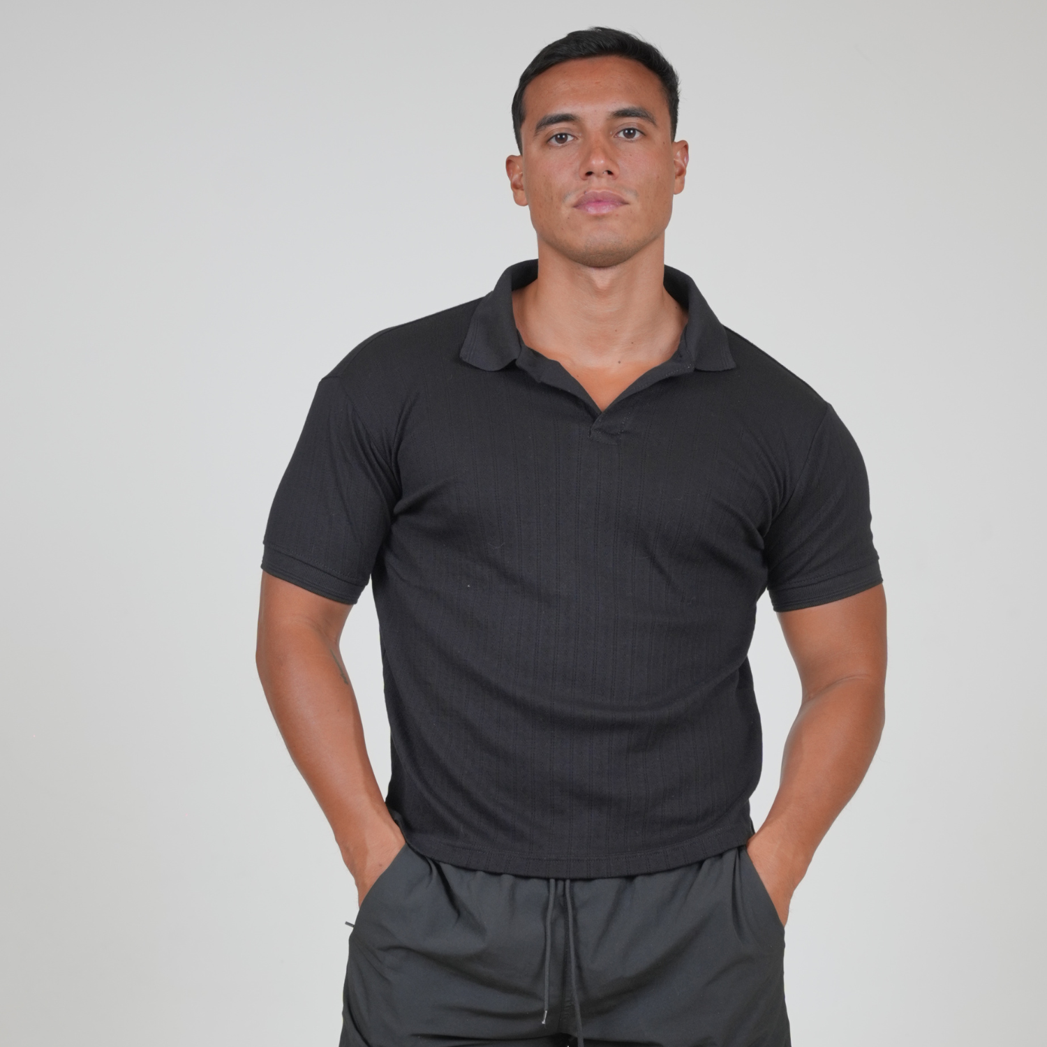 Front view of a man wearing the VERBO Tokyo Polo Tee in Noir, featuring a relaxed fit and ribbed knit texture.