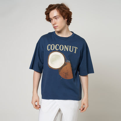 Front view of a model wearing the Stargazer blue boxy tee, highlighting the relaxed drop-shoulder fit and coconut graphic.