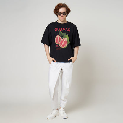 Streetwear styling of the VERBO Noir Guavas oversized tee with white linen pants and sunglasses for a minimalist look.