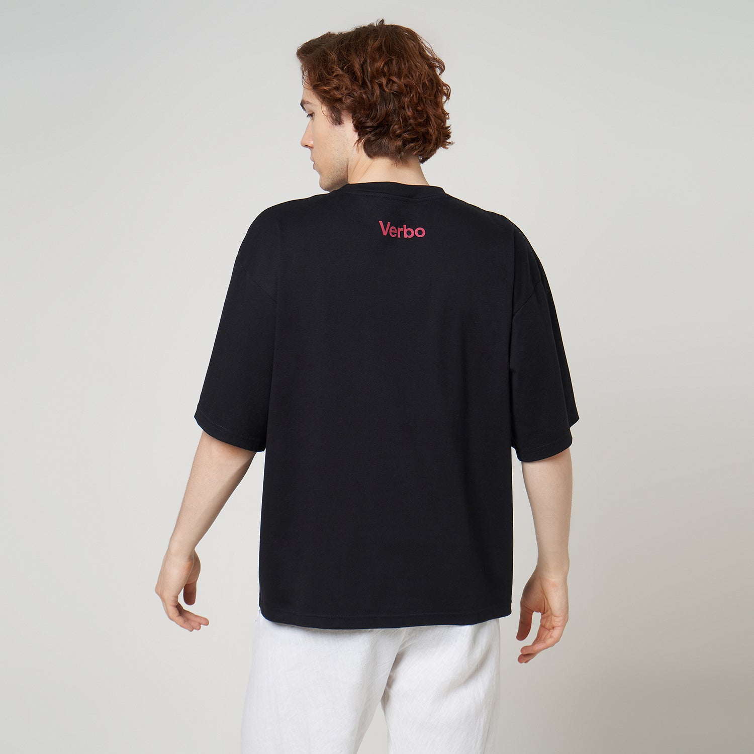 Model showcasing the relaxed drop-shoulder fit and red back branding of the VERBO Noir Guavas boxy tee.