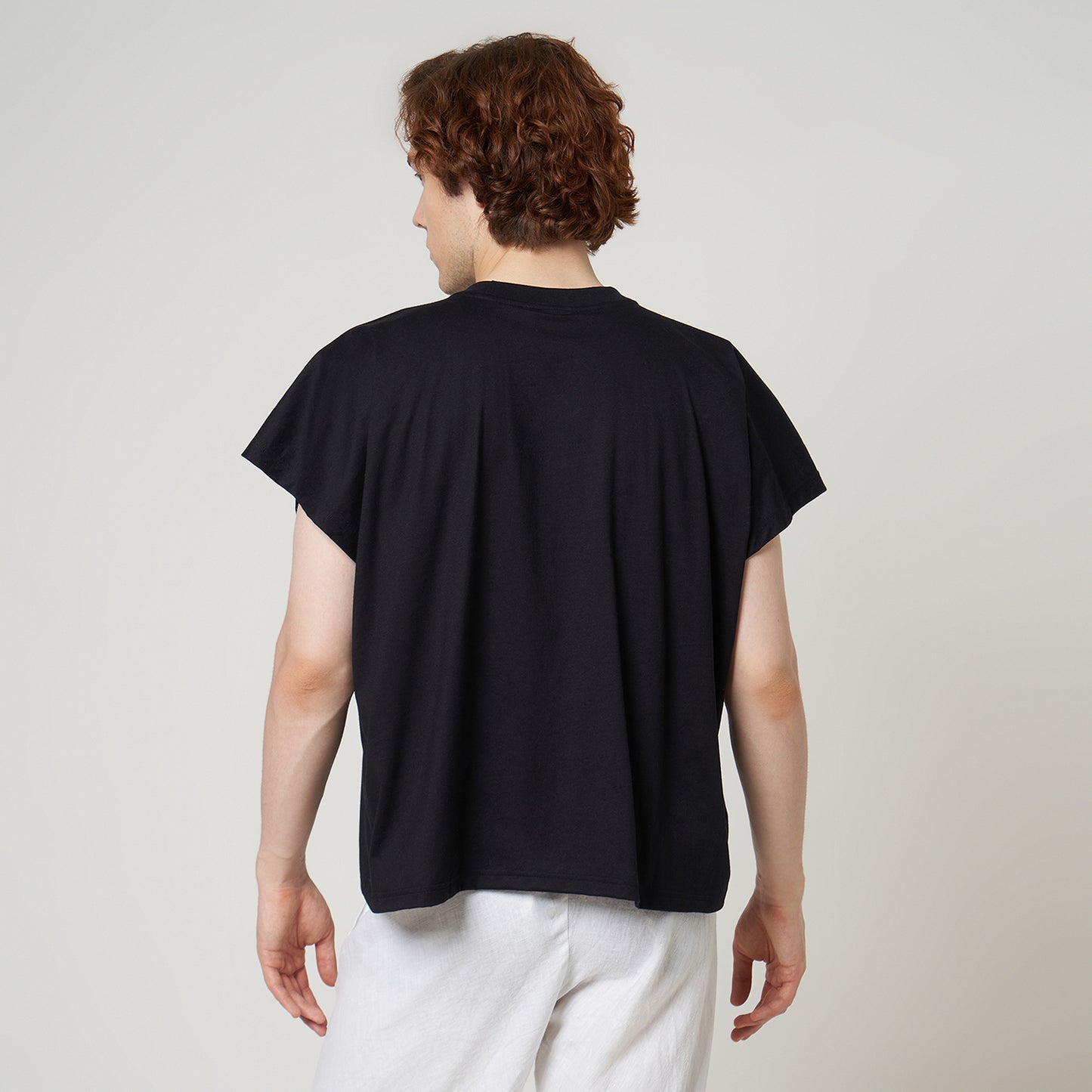 Rear view of the VERBO black cropped tank on model highlighting the relaxed drape and wide cap-sleeve style.