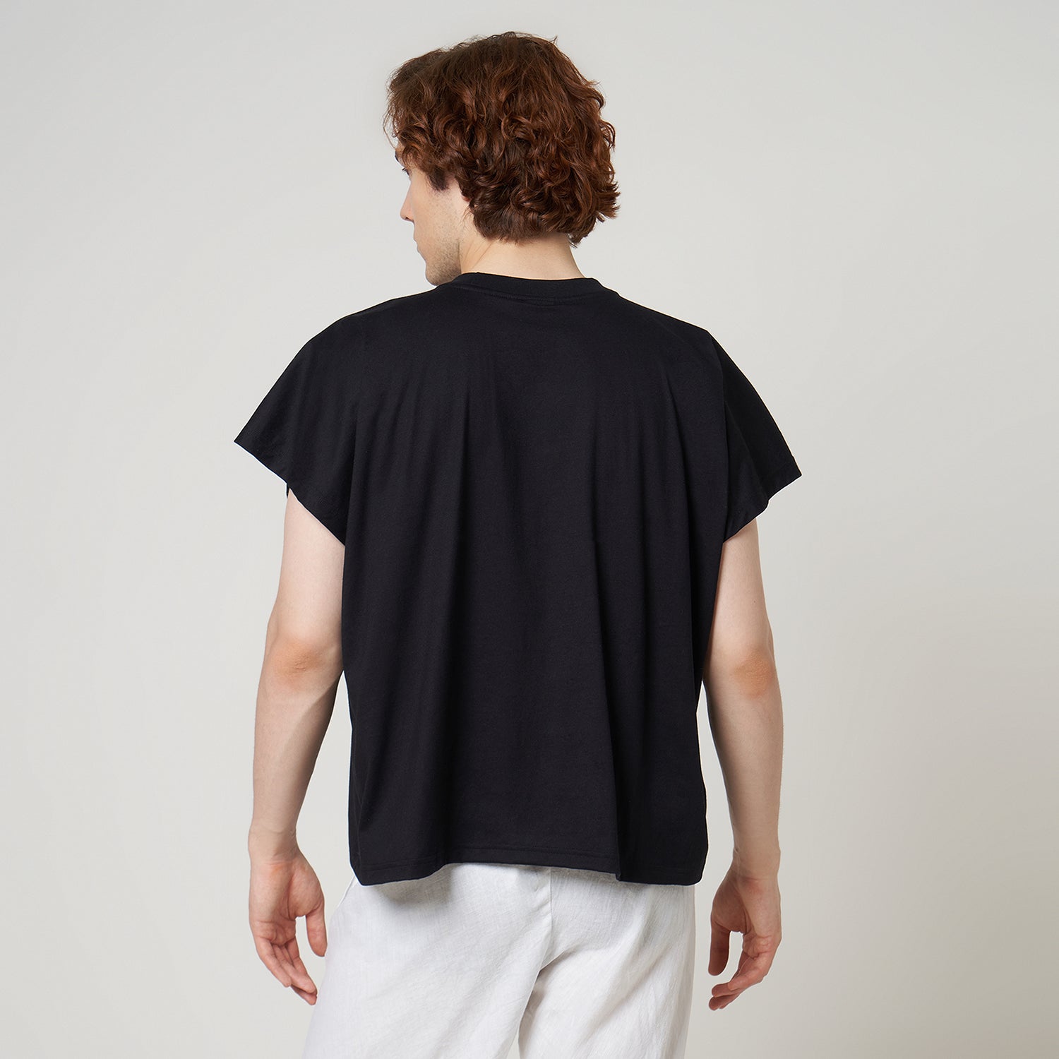 Rear view of the VERBO black cropped tank on model highlighting the relaxed drape and wide cap-sleeve style.
