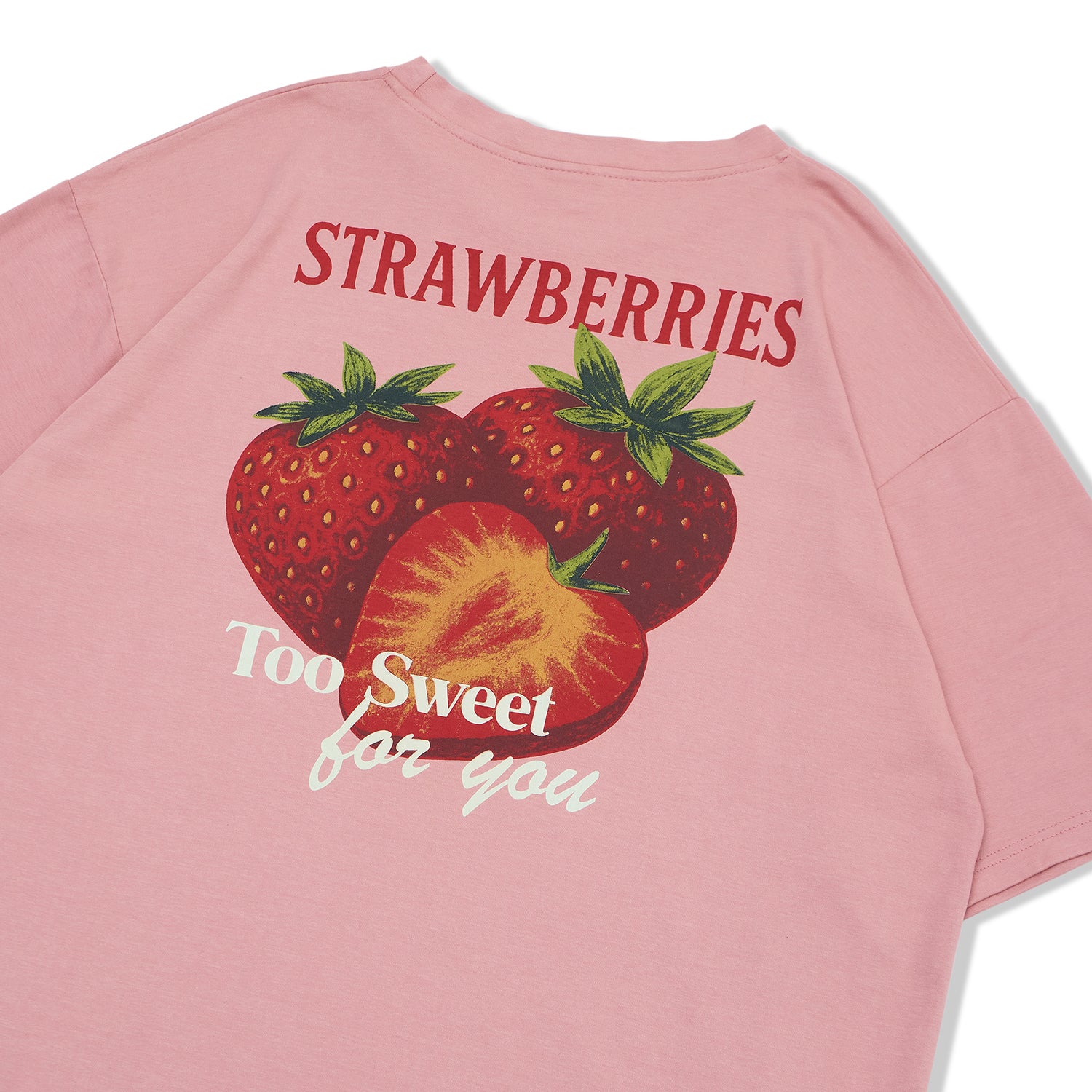 Detailed view of the back graphic on a rose tan oversized tee, featuring large red strawberries and "Strawberries Too Sweet For You" text.