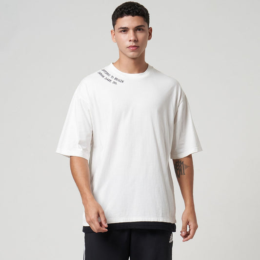 Model wearing the VERBO Inspired to Begin Layer Tee in White, showing the layered hem design and relaxed fit.